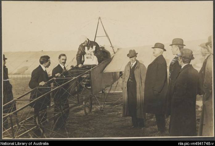 Darge, Algernon, 1878-1941. Maurice Guillaux in his Bleriot XI monoplane holding aerial mail bag at the Agricultural Society's show grounds before flying to Sydney on first air mail delivery, Melbourne, 16 July 1914 [picture]