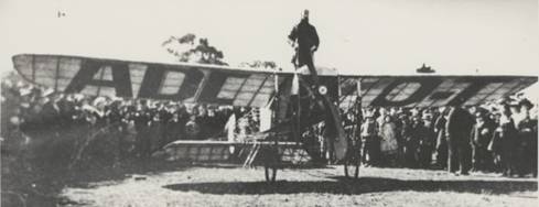  First flight from Melbourne to Sydney showing pilot Maurice Guillaux standing on a Bleriot monoplane with a 50 horsepower Gnome engine, Wangaratta, July 1914 [picture].