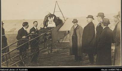Darge, Algernon, 1878-1941. Maurice Guillaux in his Bleriot XI monoplane holding aerial mail bag at the Agricultural Society's show grounds before flying to Sydney on first air mail delivery, Melbourne, 16 July 1914 [picture]